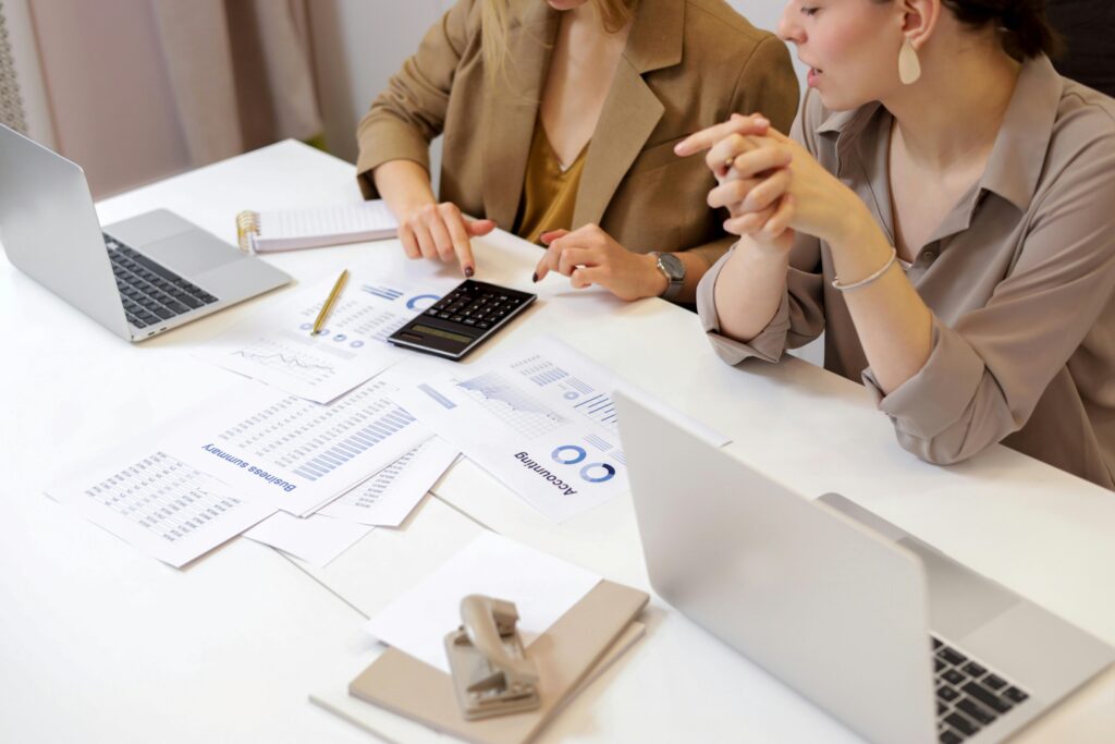 pexels-photo-6779716-6779716-2 Two professionals collaborating on financial documents in a modern office setting.